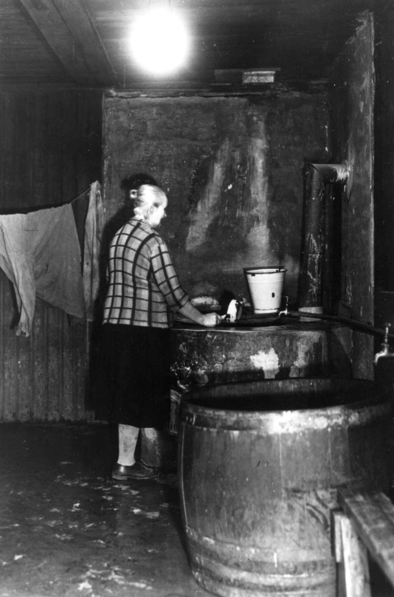 Ant. klesvask i vaskekjeller, Oslo. Kvinne i arbeid.
Fra boliginspektør Nanna Brochs boligundersøkelser i Oslo 1920-årene.