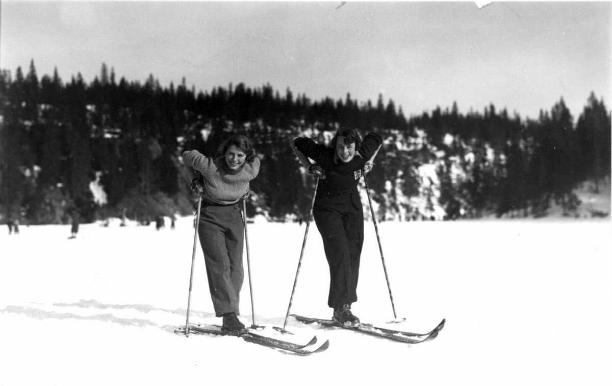 Fra slalåmrenn, Tryvannsåsen, Oslo. 1934. To kvinnelig skiløpere hviler seg på Tryvann.