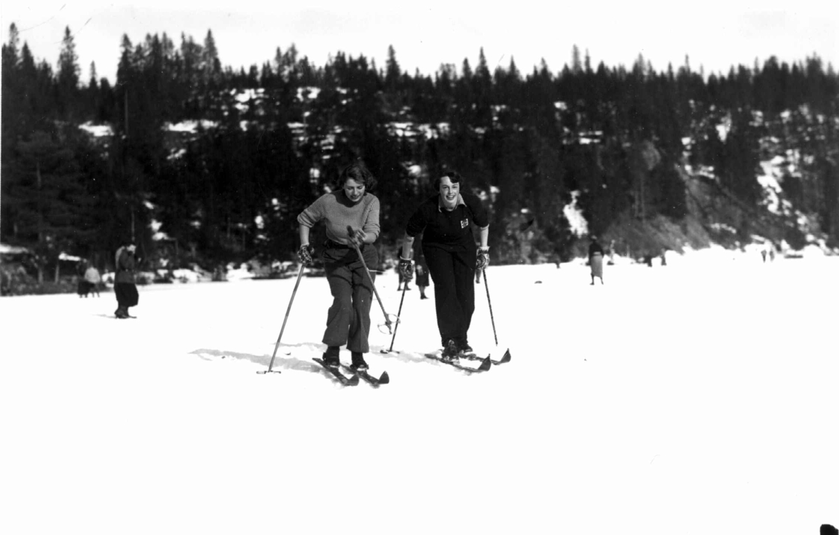 Slalåmrenn, Tryvannsåsen, Oslo. 1934. To kvinnelige skiløpere hviler ...