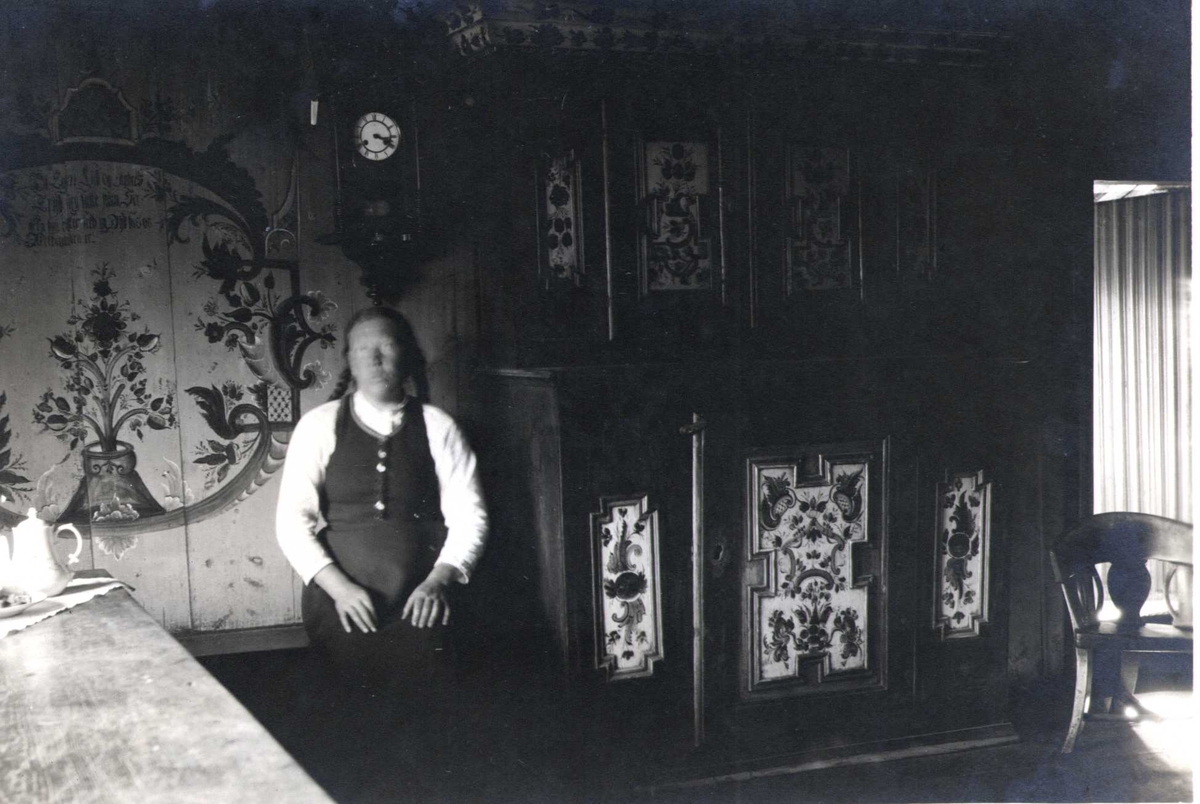 Høysete og skap i oppstuen, Botne, Berdal, Vinje, Telemark.  Fotografert 1920. Kvinne sittende ved skapet.