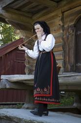St. Hansfest. Jente som spiller fløyte i Telemarkstunet.