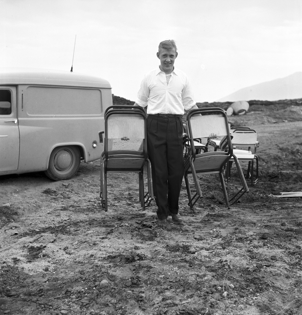 Serie. Før og under åpningen av Vigra flyplass. Mange arbeider rundt på området, noen menn står samlet og passasjerer går ombord på et Braathens safe fly. En dame står ved oppvaskbenken.  Fotografert juni 1958.
