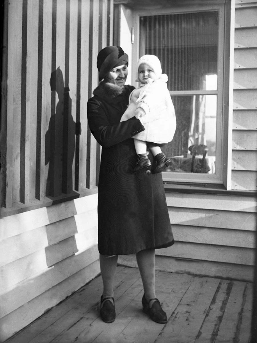 Dordi Arentz står på verandaen med sin datter Guri i armene. Fotografert oktober 1929.