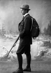 Portrett, mann med sekk og hagle, jaktkledd. Herr Trygve You