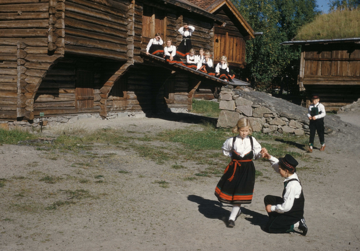 Folkemuseets barneleikaring danser i Telemarkstunet i 1957, ikledd setesdalsdrakter.
