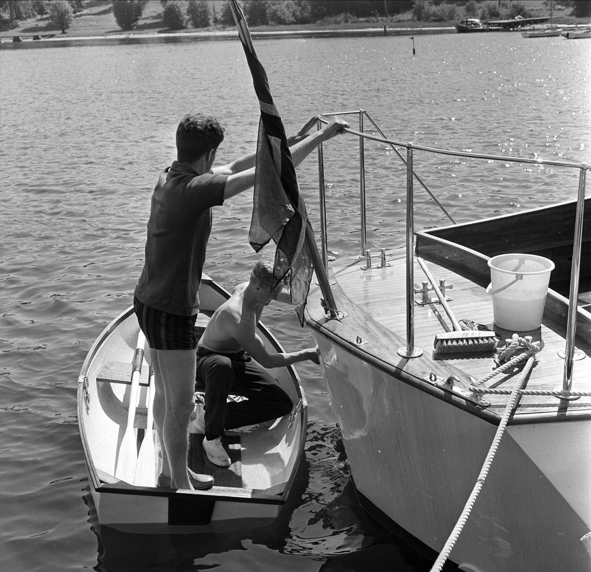 Stemning før regatta på Hankø, Fredrikstad, Østfold, juni 1964. Menn som setter flagg på seilbåt.