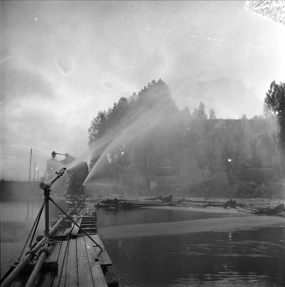 Holmen Brug i Hokksund, Øvre Eiker, Buskerud, 02.10.1958. Vannspredere på elv med tømmer.