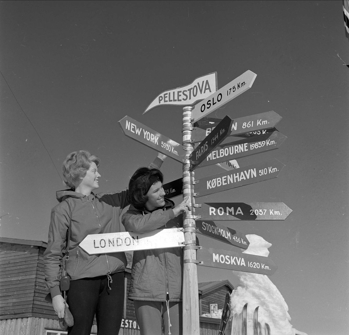 Øyer, Oppland, 25.03.1964. To kvinner ved veiviser på Pellestova.