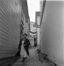 Tvedestrand, Aust-Agder, desember 1957. Bebyggelse, kvinne i