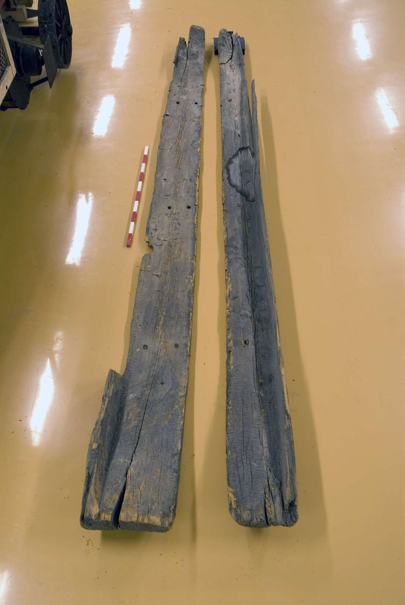 Resterna efter en sammansatt stockbåt. 
Båten består av två delar, märkta 2a och 2b.
Mått för 2a: längd 421 cm, bredd 36 cm och djup 21 cm.
Mått för 2b: längd 418 cm, bredd 27 cm och djup 18 cm.
Bottendelarna har rester efter ihopfästningen av de två delarna i form av flera borrade hål och tappar i botten av båten.
Bildbeskrivning:
Bild 1. Styrbord långsida. De två delarna placerade med ett mellanrum i mellan.
Bild 2. Detalj av fästhålen i akterbotten av båten. De två bottendelarna sammanfogades här.
Bild 3. Båten från aktern.