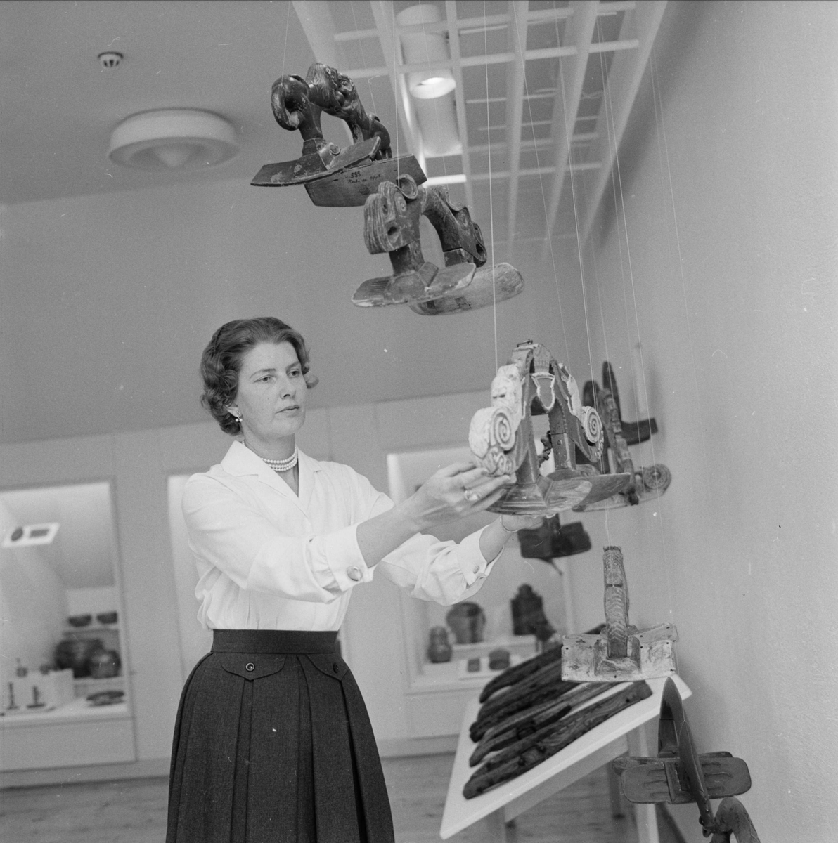 Anna-Märta Berg i galleriet för folkkonst på Upplandsmuseet som "slår upp portarna till stilfull kontakt med kultur", Uppsala juni 1959