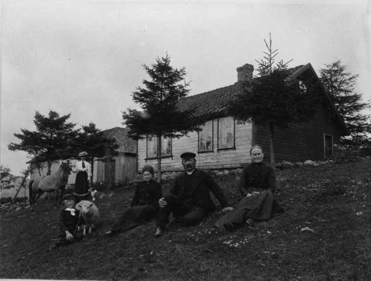 5 mennesker med hest og sau foran et hus: Tønnes Monsen, Elisabeth Eliasdatter og datteren Elisabeth Teoline. Litla-Vatne