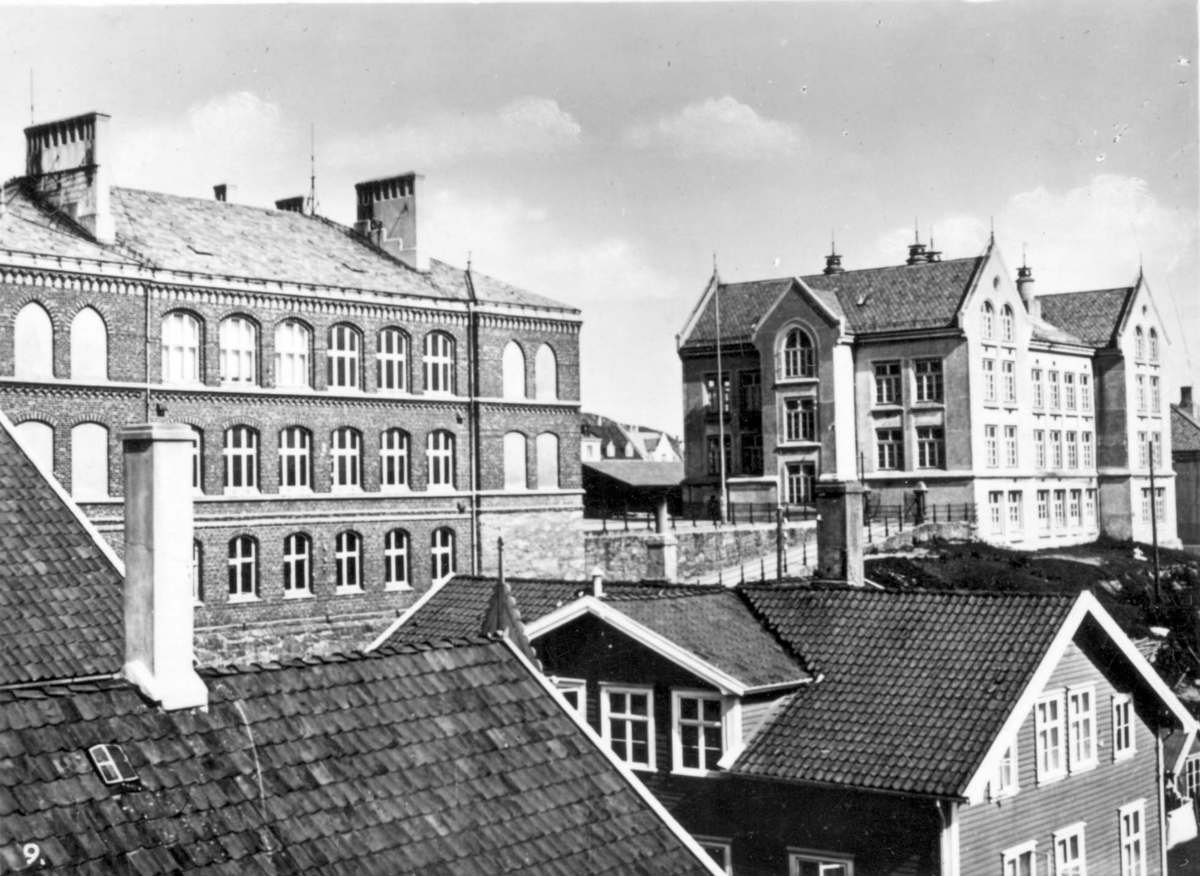 Breidablik skole sett fra nord/vest. To eldre murbygninger med trehus foran.