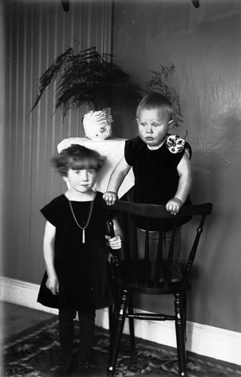 Barnporträtt  i inomhusmiljö i Galtabo, Drängsered. Evy Gustafsson med systerdotter Maj framför en piedestal. Se även HB 506