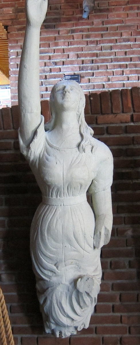 Kvinnefigur med høyre arm hevet, venstre underarm mangler.