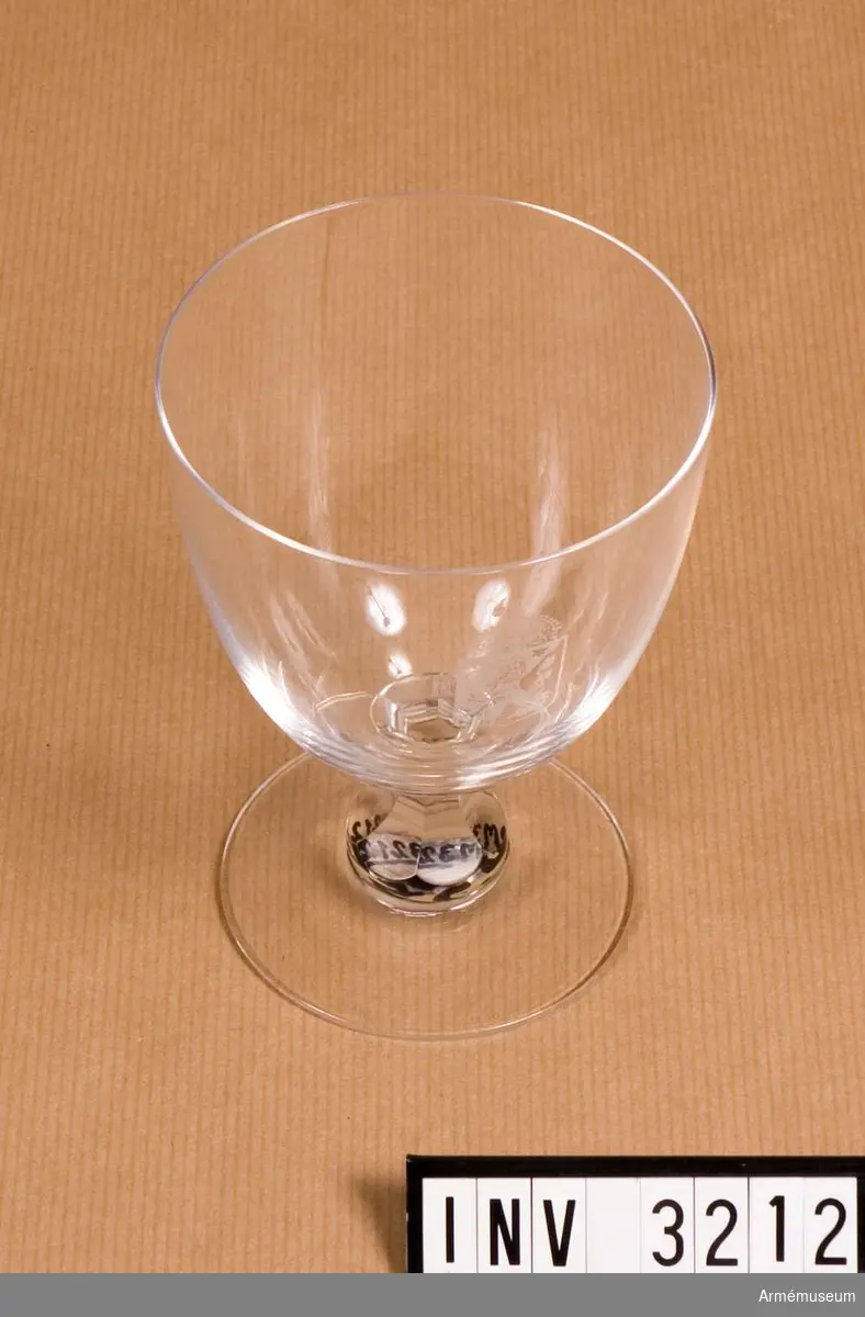 Av kristallglas med etsat vapen i form av en krönt, halverad sköld med folkungalejonet. Användes till rödvin och öl.