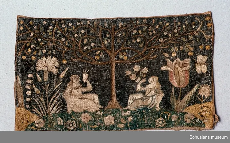Broderi på beige linne (enligt tidigaste katalogiseringen grått).
Motivet är två kvinnor sittande på gräset under ett träd. Vid sidorna och i gräset finns blommor (tulpan, nejlika, lökväxt med ensidig stängel med klockformade blommor, tusenskönor?) och insekt och fjäril.
Mönstret är gjort av silke huvudsakligen i schattérsöm, trädet i plattsöm, mitten i vissa blommor med knutar. Himlen som utgör bakgrund är sydd av metallöverdragen silketråd (troligen silver) i läggsöm.
Färgerna i broderiet är (på baksidan) olika blå nyanser, blågrönt, ljusgrönt, mörkgrönt, ljusgult, gult, olika bruna och beige nyanser, blåtonat rött, två nyanser av mycket ljust rött (rosa), gulgrönt.
Man kan se ritade eller tryckta bruna linjer för mönstrets form på linneväven.

Beskrivning i i Knut Adrian Anderssons katalog I:25:11: 
Broderi av metalltråd o vitt och gult silke på grå botten. (34 x 20;5 cm), är ett stycke av en Bönad [Bönad är bonad felstavat.] fr. 1700-talet.
Sk. av Göteborgs museum geom A. W. Malm ¾ 1880.

Trasigt i ena nedre hörnet. Brunt längs kanterna. Läggsömmen över ett par metalltrådar i ena sidan är borta. Mycket blekt.

Ur handskrivna katalogen 1957-1958:
"Broderi m. metalltråd
1870
Mått: 3,4 x 20,5 cm; broderi av silke och metalltråd på linne; två kvinnor sittande under ett träd, ngt defekt."

Lappkatalog: 73