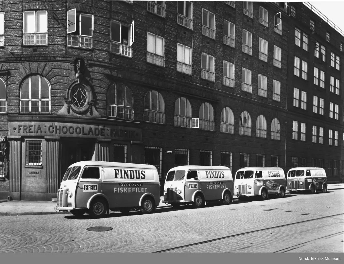 Peugeot varebiler type D-4-A 1959, levert til Findus, med reg. nr. A-39024, A-39025, A-39947 og A-38428, fotografert foran Freia Chocolade fabrik på Rodeløkka.