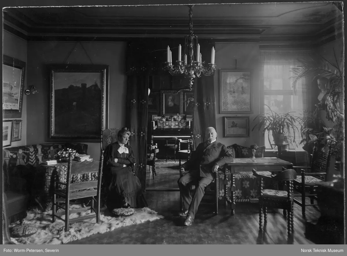 Mally og Thorvald Lammers i sin stue. I bakgrunnen sees et portrett av Mally Lammers bror, Ernst Sars.