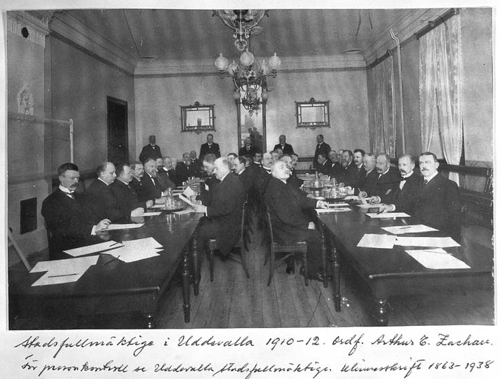 Text på kortet: "Stadsfullmäktige i Uddevalla 1910-12. Ordf. Arthur E. Zachau. 
Gåva av Direktör Axel Lange 193?".