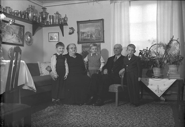 Enligt fotografens journal nr 8 1951-1957: "Olsson, Herr o Fru med barnbarn".
Enligt fotografens notering: "Herr Ernst Olsson med Fru och barnbarn Höviksnäs".