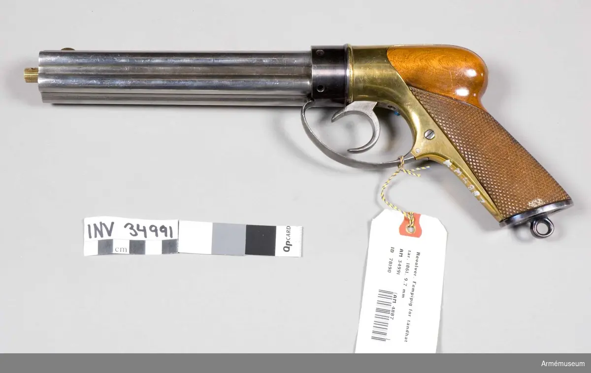 Grupp III d. 
Von Feilitzens konstruktion 1861, grundad på Colts system.Nr. 4 finns bakpå kolvbeslaget.

2008-02-15 EW
Piporna har fyra räfflor var. Dessa lossas genom att stången skruvas bort och pipknippet dras framåt tills spärrfjädern tar emot sedan vrids det motsols samtidigt som man drar lite framåt.

Tändhattsnipplarna är numrerade 6-10 vilket kan indikera att man haft ett pipknippe numrerat 1-5 för att snabbt kunna ladda om.
Nippel nr 10 liknar ej dom andra.

Kaliber 9,6 mm

Den "del" som tändhattsnipplarna går in i är numrerad 6 eller 9, denna del låses på sin plats av varbygeln. Den lossas genom att man drar den framåt och sedan nedåt. Vilket gör att delen kan skruvas bort. HÅLL avtryckaren lite spänd så att det ej tar emot!

Avfyrning fungerar genom att man spänner "hanen" med långfingret i avtryckaren och avfyrar genom att pressa den övre delen av avtryckaren med pekfingret, denna lyfts upp något när avtryckaren är i bakersta läget.

Hanen (eller slagstycket som Alm kallar det) är en rund skiva med ett uppstående segment vilket flyttas 1/5 varv vid varje avfyrning.

Att kalla detta "grundat på Colts system" av väl något oklart då piporna/pipknippet/trumman står stilla och det egentligen är hanen som roterar.

Fördelen med att ha nipplarna i bakändan, och inte vinkelrätt mot pipan som är det vanliga, är att vapnet blir smalt.

Enligt Alm provades vapnet 1863.

August Gustaf Reinhold von Feilitze var besiktningsofficer vid Husqvarna faktori 1852 och 1858. Han stämplade med initialerna RvF.