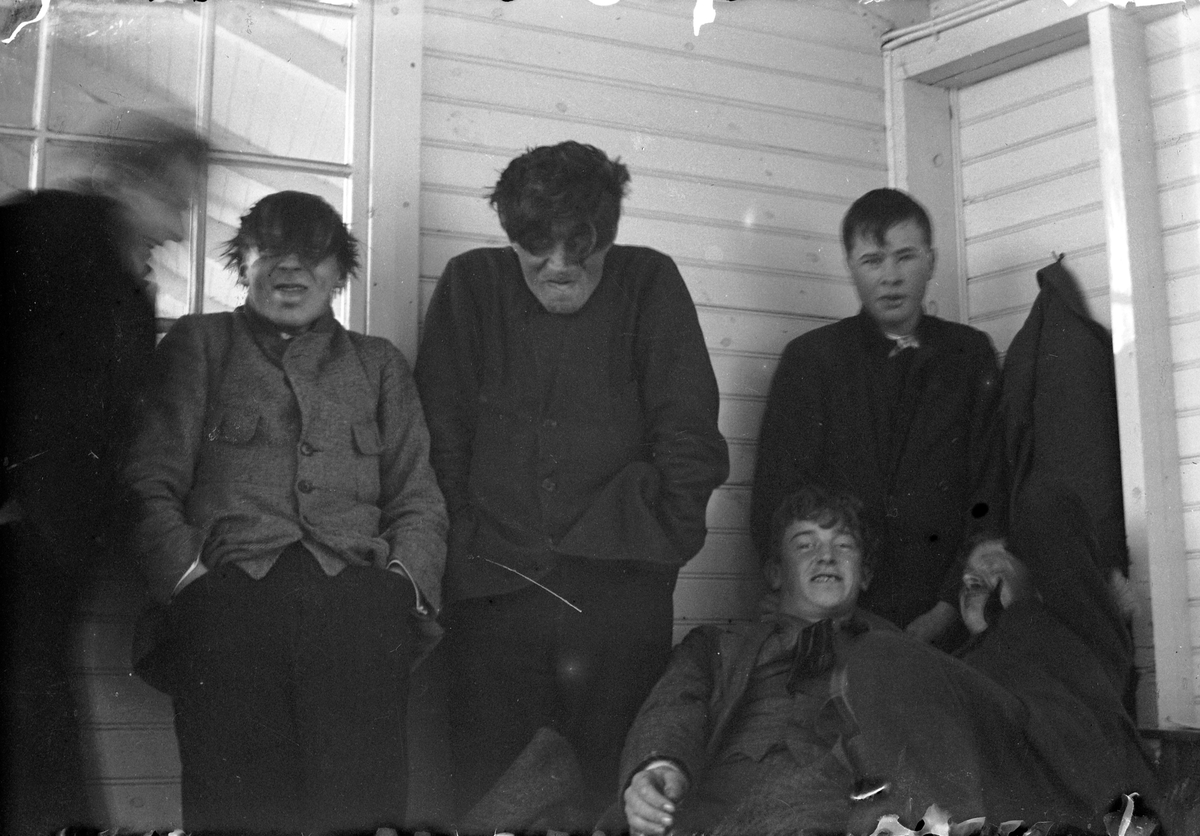 Sex unga män lutar sig mot en trävägg med fönster. Lungkliniken i Eksjö.
