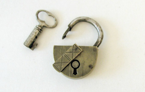 Hänglås till klockarpostväska PM 17199 med tillhörande
nyckel. Hänglåset har en klaff att fällas över nyckelhålet.