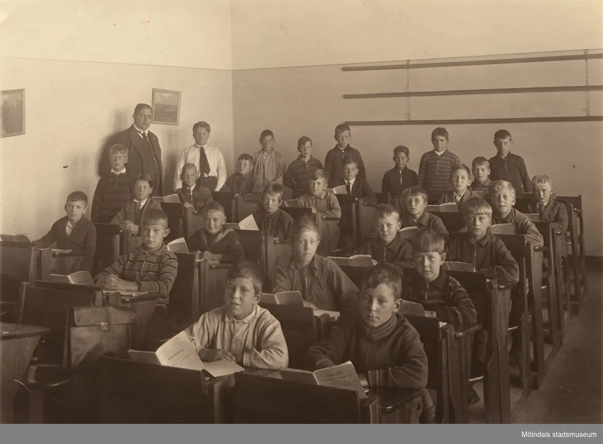 Pojkar sittande i bänkar med räkneböcker framför sig på Kvarnbyskolan i Mölndal år 1952.