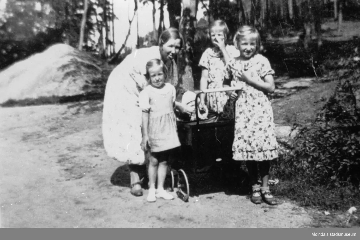 Svea Larsson står tillsammans med flickorna Siv, Britt och Anne-Marie runt en barnvagn med lille Ebon i. 1938 på Åbybergskullen.