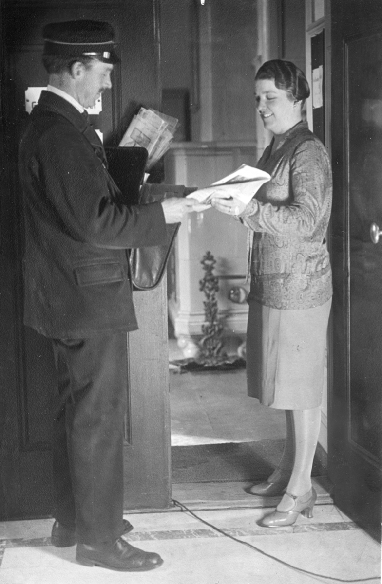Brevbärare O.D. Andersson på postkontoret Stockholm 1, delar ut post till kund i 10:e distriktet, 1935.