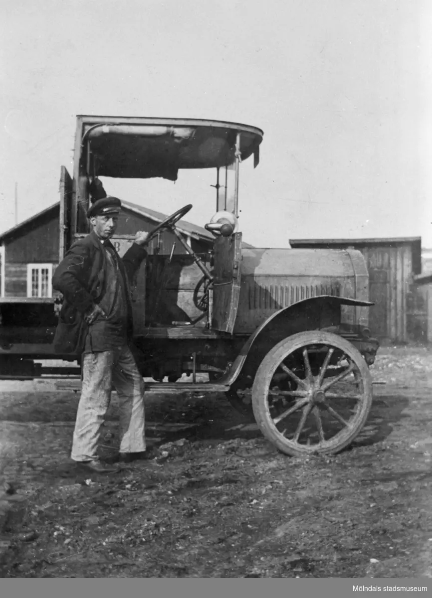 Chauffören Viktor Karlsson står utanför en lastbil vid Forsåkers fabriker i Forsåker, cirka 1900-1910. Relaterat motiv: 1993_0169.