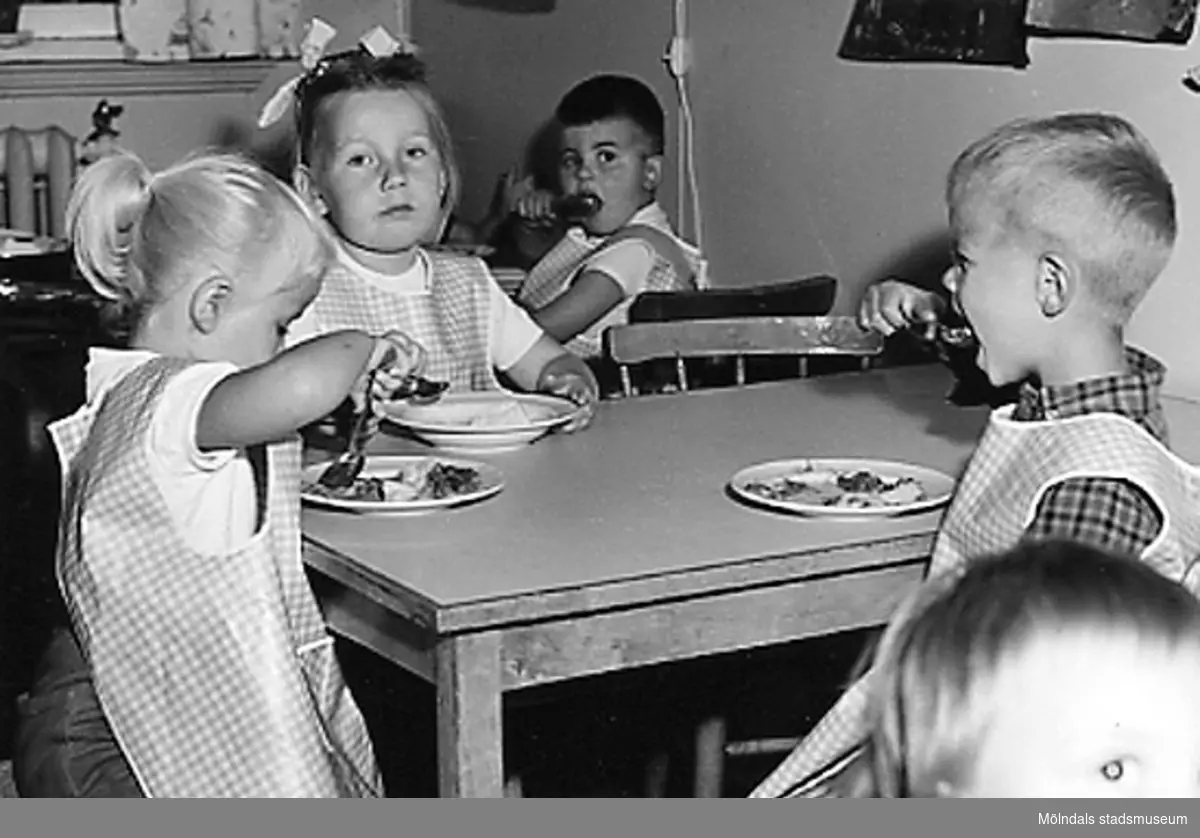Barn sitter runt ett bord och äter i köket. Holtermanska daghemmet 1953.