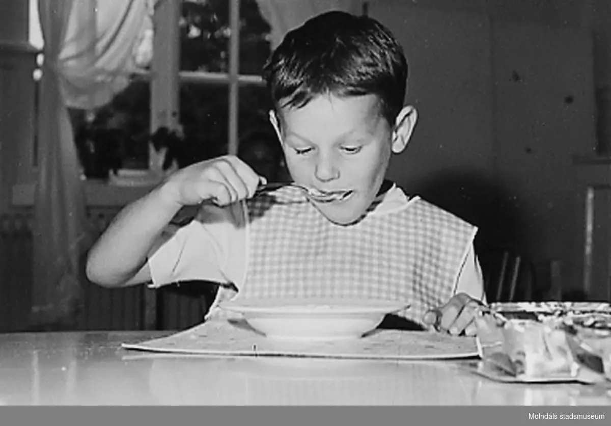 En pojke som äter mat på Holtermanska daghemmet 1953.