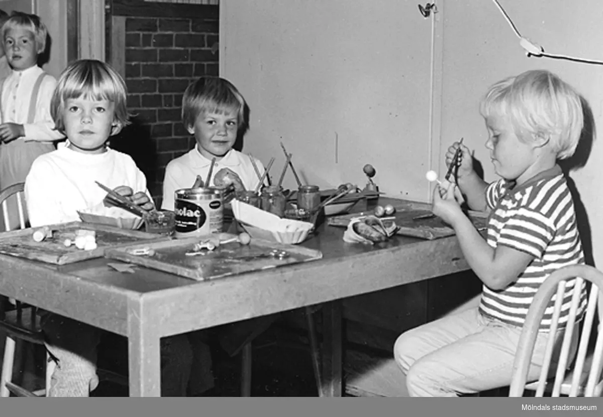 Några barn sitter och målar vid ett bord. Holtermanska daghemmet 1953.