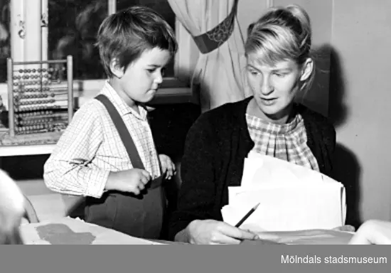 Lärarinna och barn pysslar. Holtermanska daghemmet 1953.