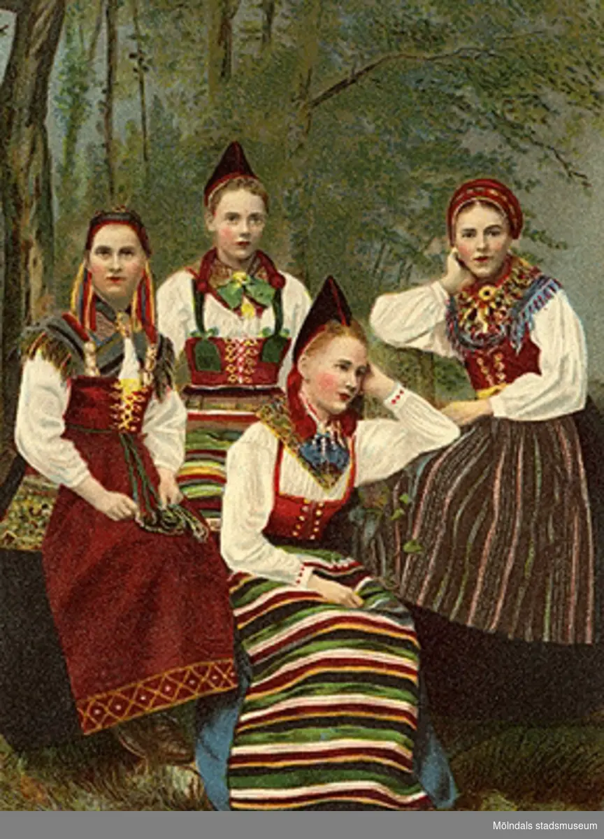 Fyra folkdräktsklädda, unga kvinnor, 1890-tal. Fotot är färglagt (kolorerat) i efterhand.