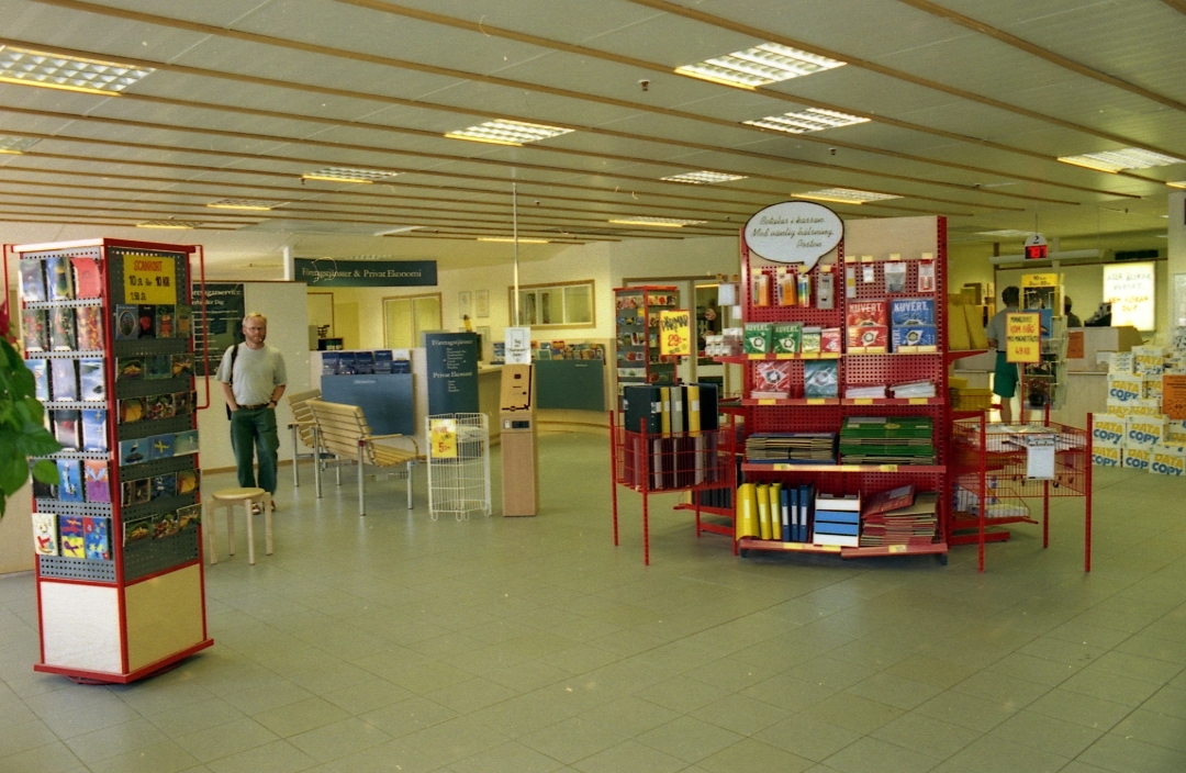 Allmänhetens avdelning på regionpostkontoret Kungshörnet i Uppsala, 1996. I öppna säljmontrar på golvet utbjuds kuvert, paketkartonger och kontorsmaterial mm.