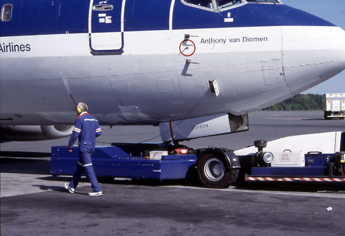 Lufthavn, nesepartiet til 1 fly på bakken under taxing, Boeing 737 306, PH-BDD "Anthony van Diemen" fra KLM.  1 person, bakkepersonell, foran flyet.  1 kjøretøy i bakgrunnen.