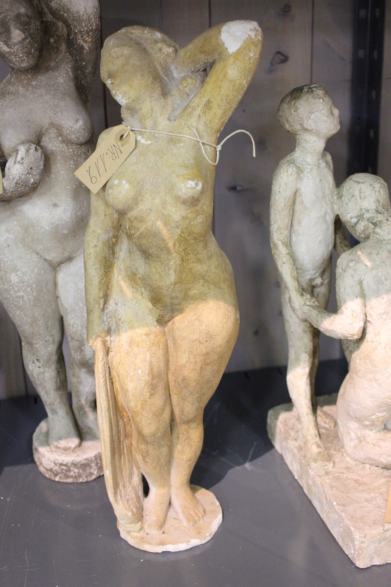 Skulptur i gips av en kvinne med den ene hånden i håret og den andre med et klede. Tittel: "ETTER BADET"
