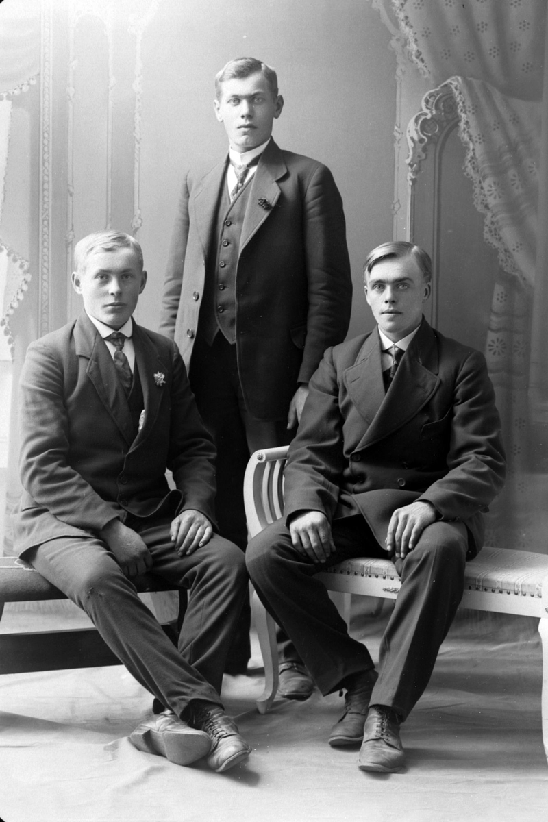 Studioportrett av tre menn.