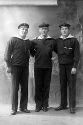 Studioportrett i helfigur av tre marinegaster.