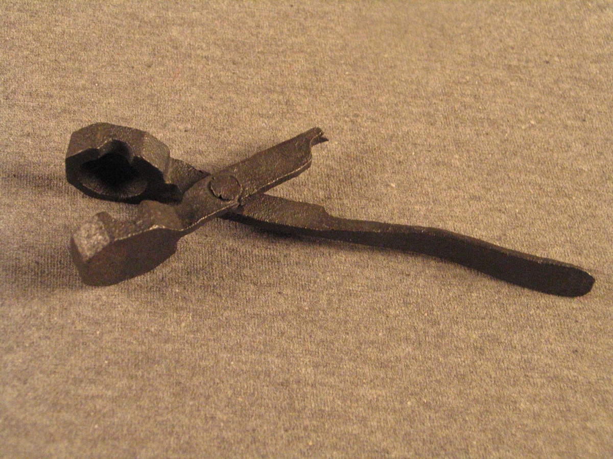 Støypeforma er forma som ei tang. Ved å klemme att tanga lukkar ein støypeforma.