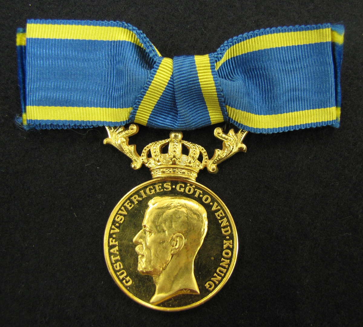 Medalj till Emmy Helena Anna Helander för nit och redlighet i rikets tjänst.  Finns ett etui till medaljen (VM09633:c). 

Medaljen är av 23 K guld försedd med krona och bärornament av 18 K guld.