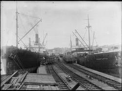 Lasteskip i Sarpsborg havn. Lasting av tømmer, flere menn hj