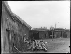Bakgård med uthus, materialstabel,, og dueslag, ant i Sarpsb