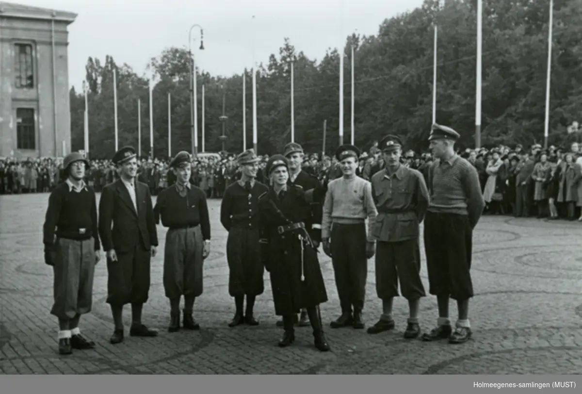 En menneskemengde utenfor Universitetet i Oslo. Noen uniformerte menn står midt på plassen.