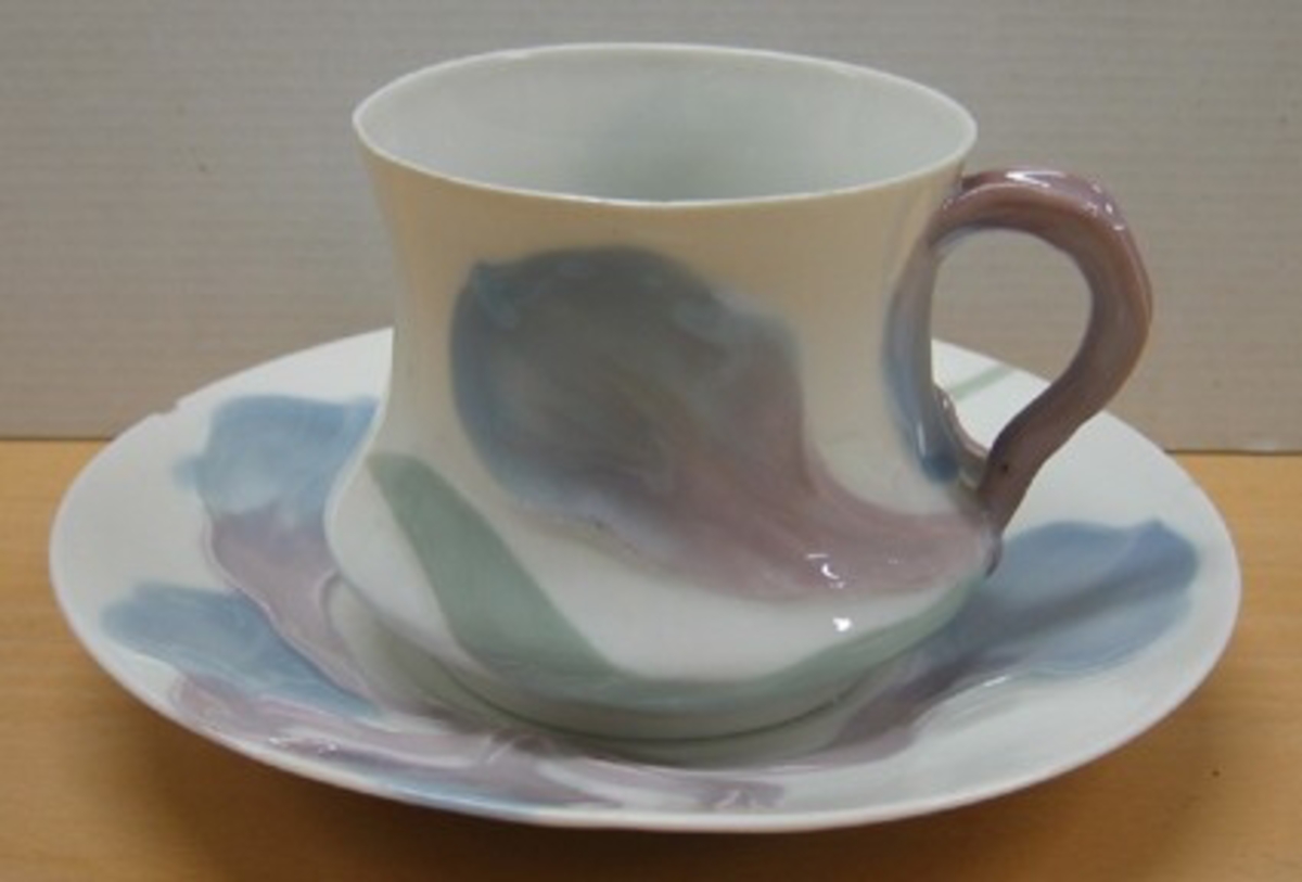 Kaffekopp med fat ur serien Iris/ Liljor tillverkad vid Rörstrands porslinsfabrik efter design av Alf Wallander. Från år 1897.

Motiv/dekor: Iris