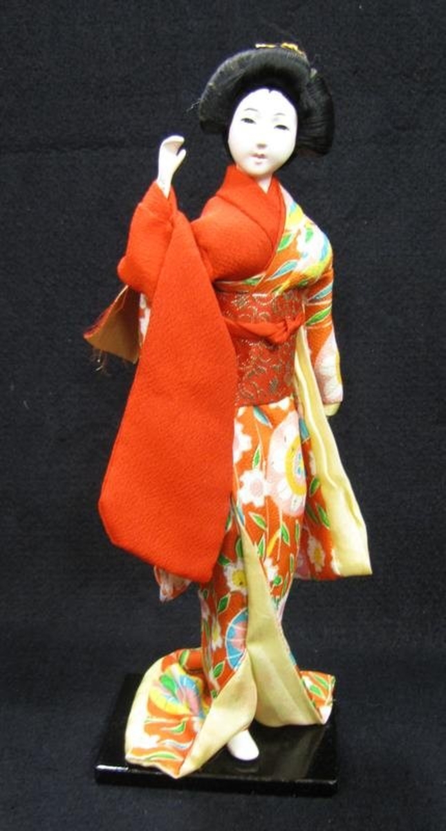 Tillhör Vera Hanssons docksamling.

Köpt 1960. Tatsue, Kyoto Hondo. Japan.
Rödblommig kimono med gult foder. 
Bär ok med 2 ämbar.