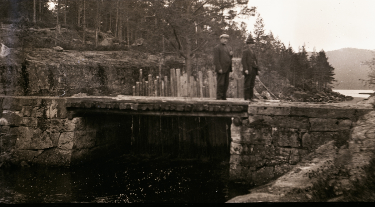 Hålkåa: mellom Holmvaten  og Reisjåvatn i Hovin-Tinn Mannen til høyre med hvit hatt heter Kristiansen og var sjef for fløtinga. Og Skogfullmektig Anton Aas